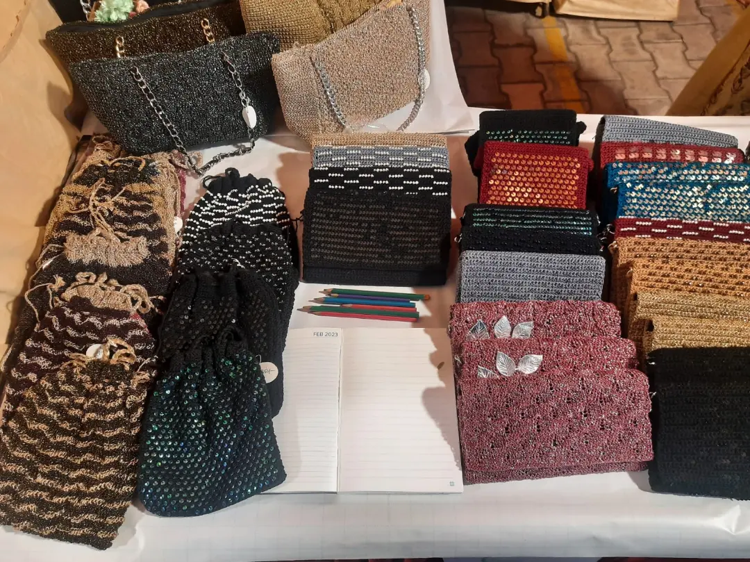 Rows of finished clutches on her exhibition table, every one a different colour and stitch.