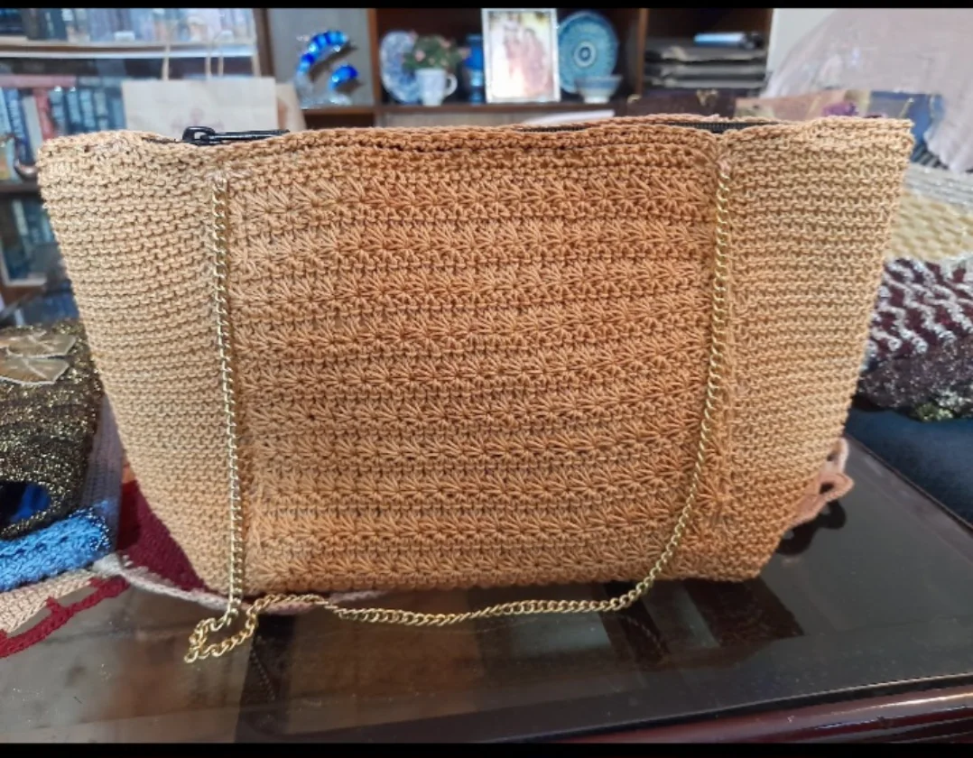 A gold tote worked in a star-pattern stitch, with a chain strap.